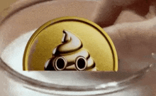 a gold coin with a poop face on it