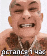 a man with a tattoo on his face and a necklace around his neck is smiling with his eyes closed