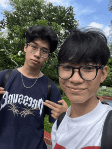 two young men are posing for a picture with one wearing a shirt that says " squeeze " on it