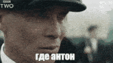 a close up of a man 's face with the words peaky blinders in russian on the bottom .