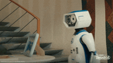 a robot is standing in front of stairs with fantastic 4 written on the wall behind him