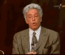 a man in a suit and tie is making a funny face with his mouth open