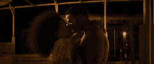 a man and woman are kissing in a dark room .