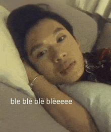 a man laying on a bed with the words ble ble ble bleeeee written below him