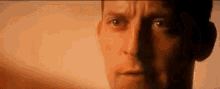 a close up of a man 's face with a shadow behind him .