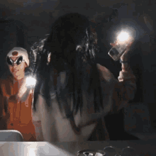 a group of people are dancing in a dark room with glasses on a table
