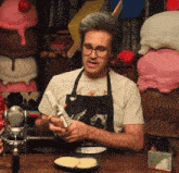 a man wearing an apron that says mythical is holding a cell phone