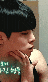 a close up of a man 's face with korean writing on the bottom right
