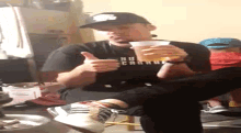 a man wearing a new york yankees hat is holding a cup of beer
