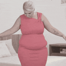 a woman in a pink dress with a tattoo on her arm