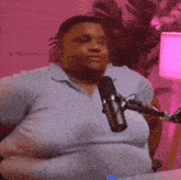 a man is sitting in front of a microphone in a room