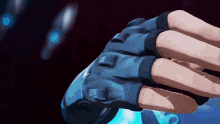 a person wearing a pair of blue gloves is holding a remote control in their hand .
