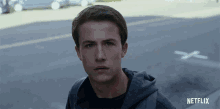 a young man standing in front of a netflix logo