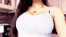 a woman wearing a white tank top and a necklace