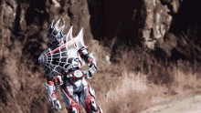 a superhero with a spider web on his back is walking on a dirt road