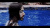 a man with long hair and a beard is standing in a pool of water