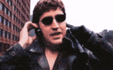 a man wearing sunglasses talks on a cell phone