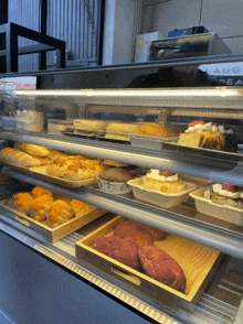 a variety of pastries are displayed under a glass display case with a laura dea machine behind it