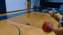 a person is playing basketball in a gym with a mascot