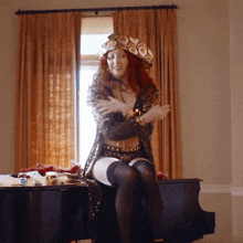 a woman is sitting on a piano wearing a hat and stockings