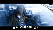 a man in a brown jacket is driving a car with korean writing on the screen