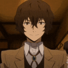 a close up of a person wearing a suit and tie with a necklace .