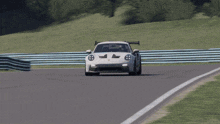 a white porsche gt3 rs is driving down a track