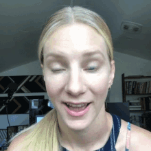 a woman with her eyes closed looks at the camera