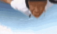 a person is laying on a blue surface with their head in the air .