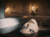 a woman is laying in a bathtub with her face in the water