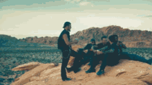 a group of people sitting on rocks in the desert