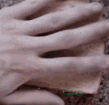 a close up of a person 's hand with a green circle around the thumb