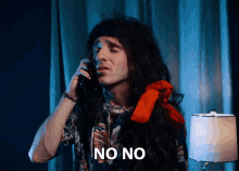 a man with long hair is talking on a phone and the word no is on the screen