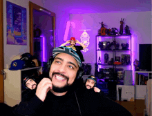 a man with a beard wearing headphones and a hat with the letter t on it