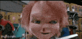 a doll with a bloody nose is holding a pair of scissors in a store .