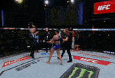 a ufc fight takes place in a boxing ring with budweiser and espn on the floor