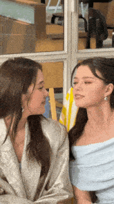 two women are sitting next to each other and looking at each other