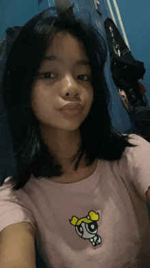 a girl wearing a pink shirt with a powerpuff girl on it