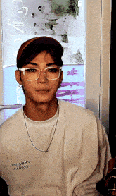 a young man wearing glasses and a white shirt that says ' nia2n9j9 ' on it