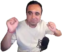 a man wearing headphones and a white shirt is standing in front of a microphone