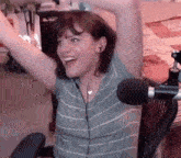 a woman is sitting in a chair with her arms in the air and wearing headphones .