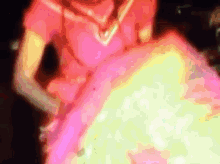 a woman in a pink dress is standing in front of a large fireball .