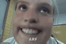 a close up of a woman 's face with the word arf written on the bottom .