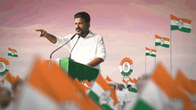 a man stands at a podium giving a speech surrounded by flags with the congress logo