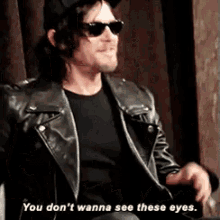 a man wearing sunglasses and a leather jacket says you don t wanna see these eyes .