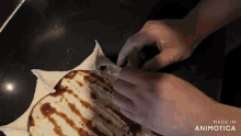 a close up of a person making a cake with the words made in animatica
