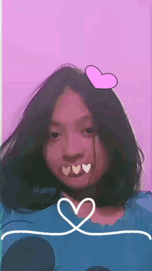 the girl is wearing a blue shirt and has a pink heart on her head