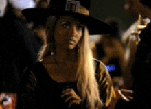 a woman in a witch costume is smoking a cigarette .