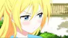 a girl with blonde hair and blue eyes is making a funny face in front of a bridge .
