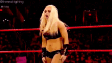 two women are wrestling in a ring and one of them is wearing a bikini .